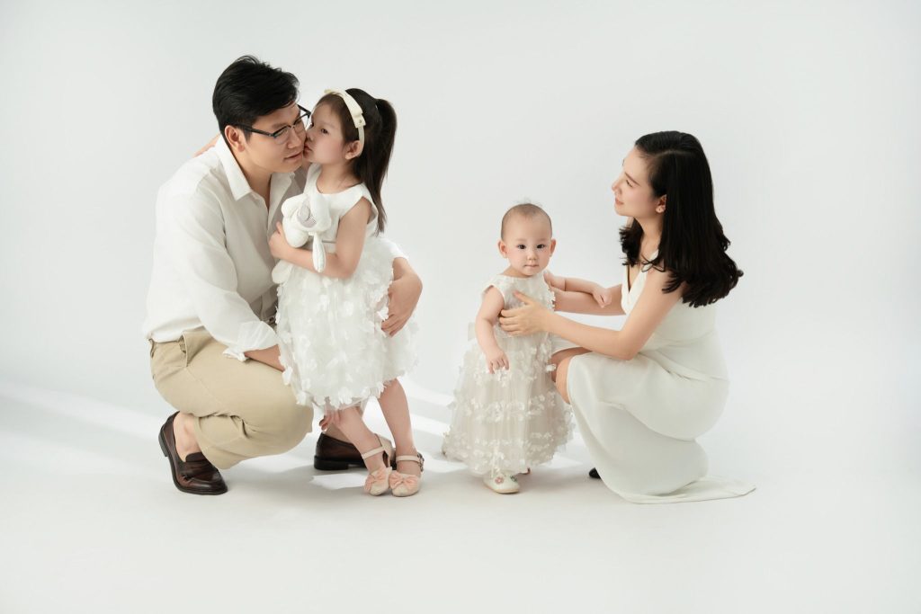 Gia đình có hai bé tương tác với nhau trên nền sáng