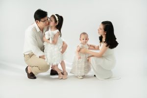 Gia đình có hai bé tương tác với nhau trên nền sáng