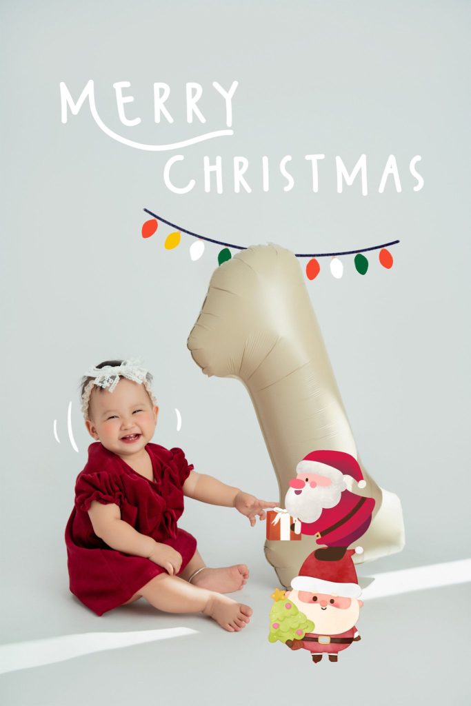 Bé mặc váy đỏ bên bóng số 1, với chữ Giáng sinh và hình ông già Noel trên nền sáng