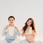 Mẹ bầu và bạn đời ngồi tạo dáng vui trong studio