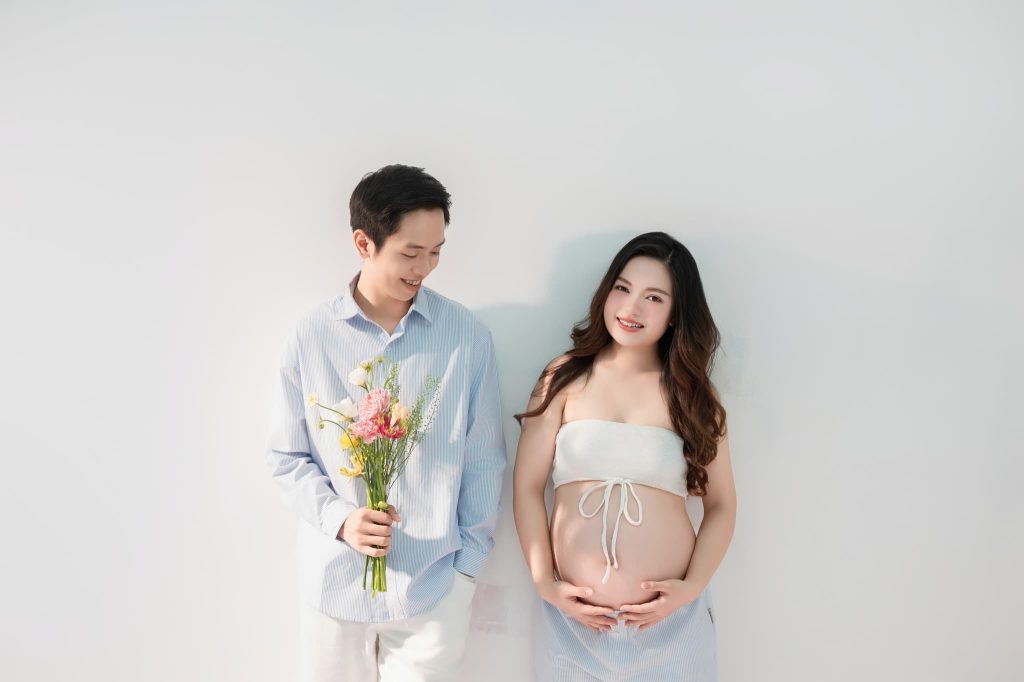 Mẹ bầu và bạn đời đứng cùng hoa trong bộ ảnh tông sáng