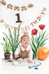 Bé ngồi bên bánh và phụ kiện sinh nhật một tuổi chủ đề cây quả