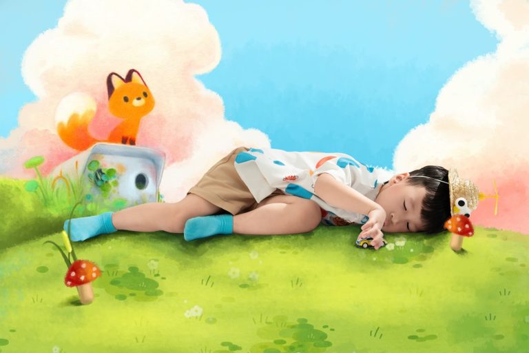 Bé nằm trong bối cảnh đồng cỏ và nhân vật hoạt hình minh họa