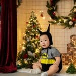 Bé ngồi tạo dáng cùng cây thông trong bộ ảnh Giáng sinh