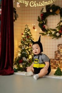 Bé ngồi tạo dáng cùng cây thông trong bộ ảnh Giáng sinh