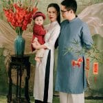 Ba mẹ mặc áo dài trắng xanh cùng nhìn bé áo dài đỏ