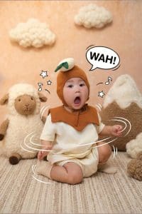 Bé ngồi nhìn sang bên cạnh dòng chữ minh họa trên nền nâu