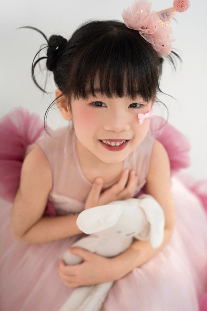 Độ tuổi chụp ảnh mẫu nhí: chọn hoạt động theo khả năng thật của bé 1 Chân dung bé trong váy hồng, tựa tay và mỉm cười