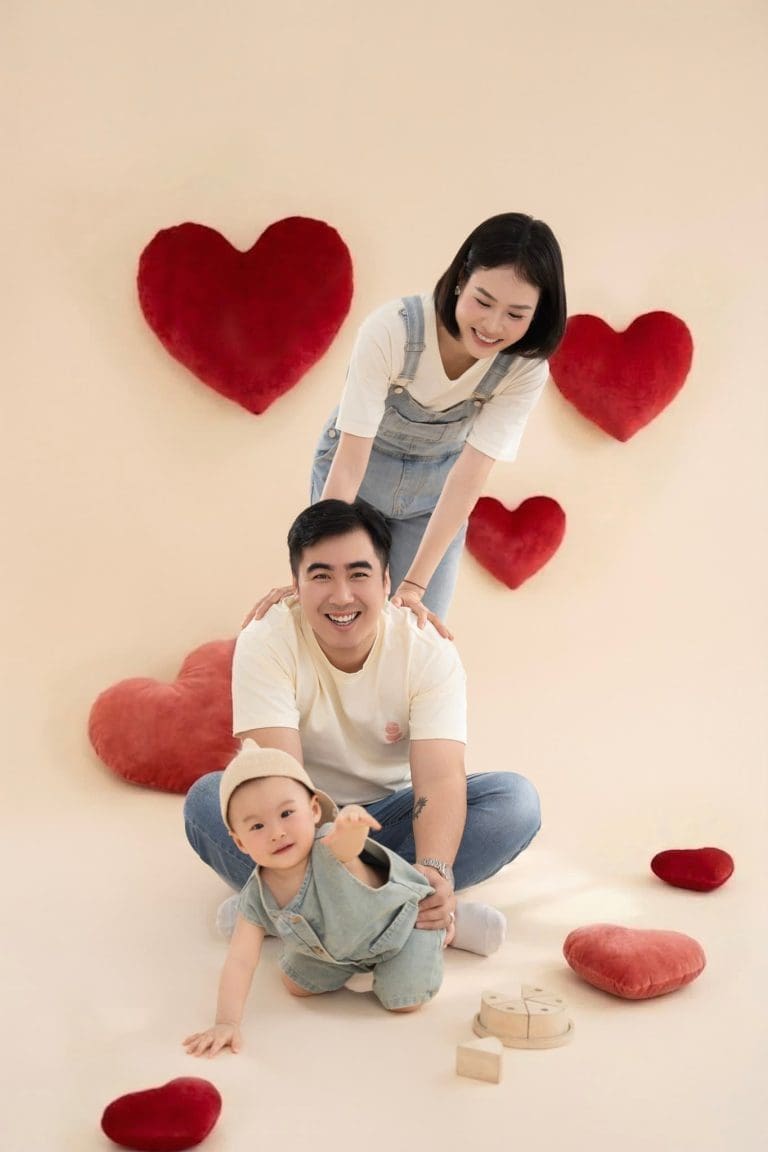 Gia đình ba người chụp ảnh cùng phụ kiện trái tim đỏ