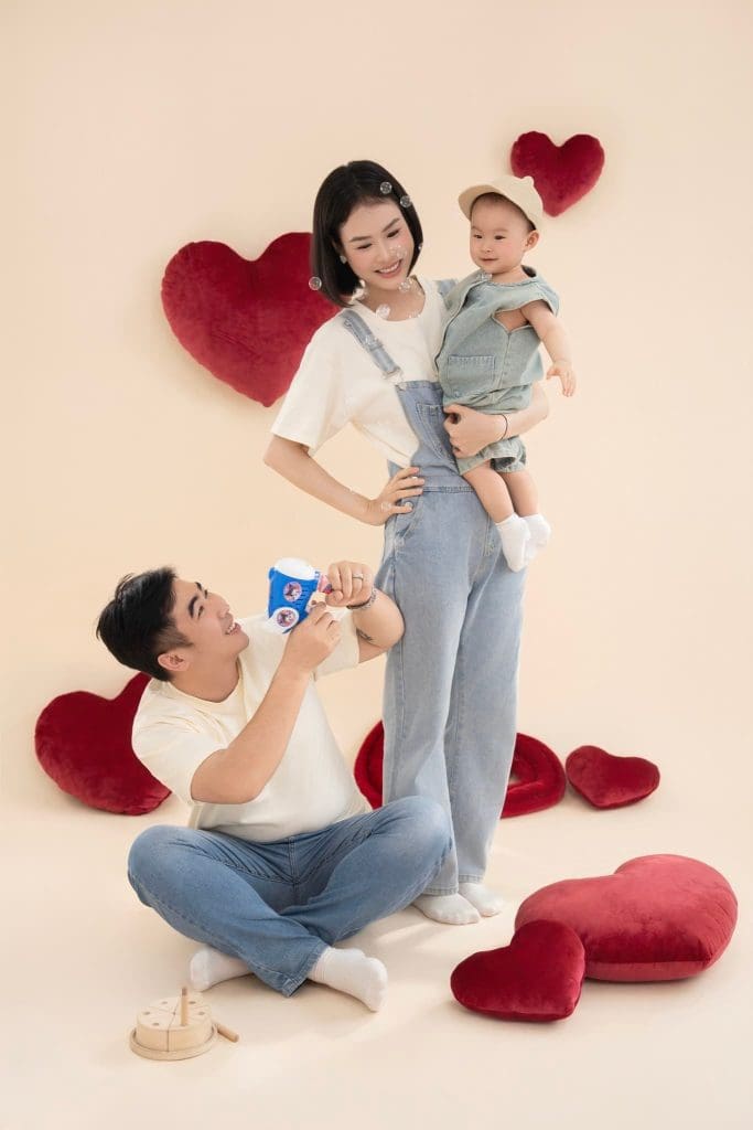 Ba mẹ tương tác với bé trong bộ ảnh gia đình có đạo cụ trái tim