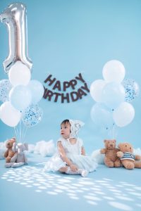 Bé ngồi bên bóng số một và phụ kiện sinh nhật tông xanh